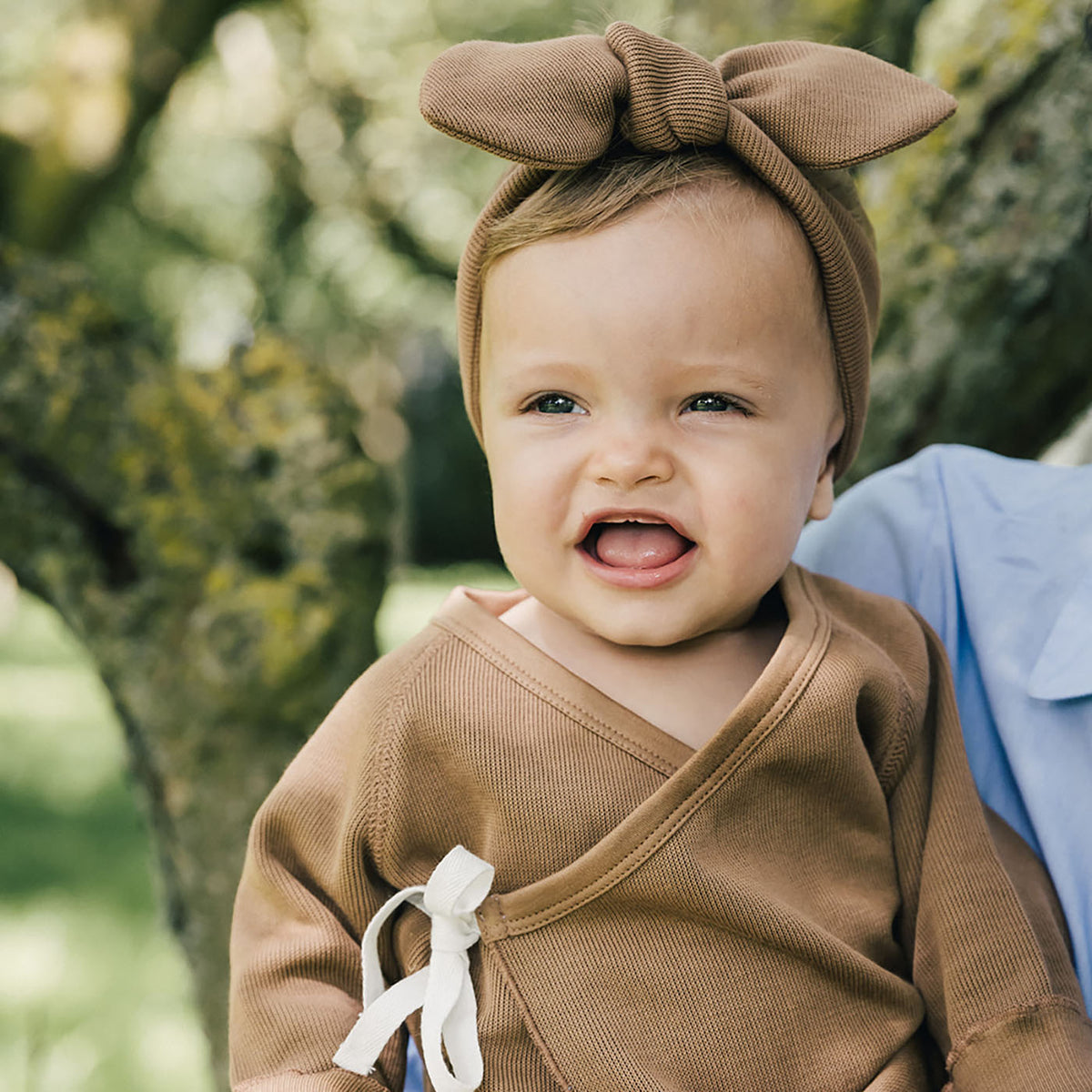 baby being held wearing uaua head bow in chocolate and kimono romper in chocolate